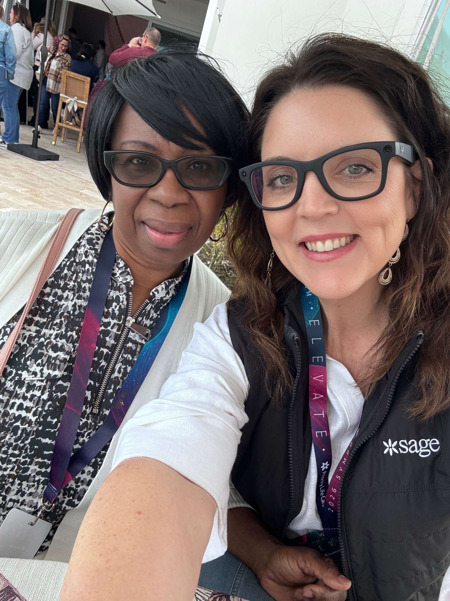 Two caregivers smiling together at a Sage event